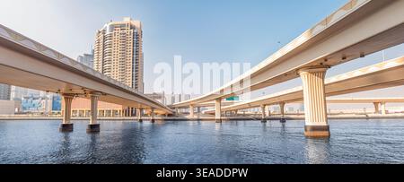 12. Januar 2026, Dubai, VAE: Brücken über einen blauen Kanal, die städtische Gebiete mit moderner Infrastruktur und zeitgenössischer Architektur verbinden Stockfoto