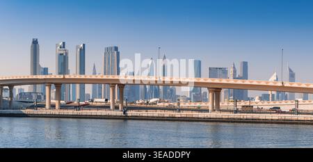 12. Januar 2026, Dubai, VAE: Stadtbild mit modernen Wolkenkratzern und einer gekrümmten Brücke über den Wasserkanal. Stadtentwicklung Stockfoto