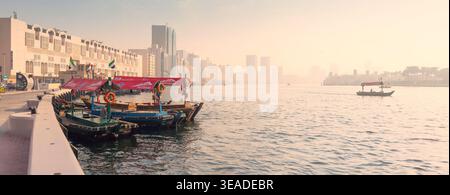 12. Januar 2026, Dubai, Vereinigte Arabische Emirate: Traditionelle Abra-Boote warten auf Passagiere auf Creek, mit der historischen Skyline von Bur Dubai und dem Moscheeminarett im bac Stockfoto