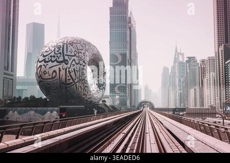 12. Januar 2026, Dubai, VAE: Museum of the Future-Struktur mit arabischen Kalligrafie-Details, umgeben von modernen Wolkenkratzern und erhöhter U-Bahn-Bahn-Bahn Stockfoto