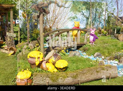 Harrogate Flower Show, Nth Yorkshire, 22. April 2026. Die Aussteller bereiten Stände vor, um die Eröffnung der Blumenausstellung vorzubereiten. Diese Ausstellung wurde von Horticap, einer in Harrogate ansässigen Gartenbauorganisation für Erwachsene mit Lernbehinderungen, erstellt. Es zeigt eine skurrile Gartenausstellung mit Figuren Puuh Bär und Ferkel, Kreationen von A. A. Milne, auf einer Holzbrücke am Harrogate Flower Show. Die preisgekrönte Ausstellung wurde von den Mitarbeitern der Wohltätigkeitsorganisation Erica Ward und Emma Hudson mit Freiwilligen und Studenten geleitet. Bridget Catterall/AlamyLiveNews. Stockfoto