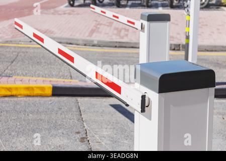Auslegersperrenarm, der das ein- und Aussteigen des Fahrzeugs auf einem privaten Parkplatz steuert, symbolisiert Sicherheit und Zugang Stockfoto