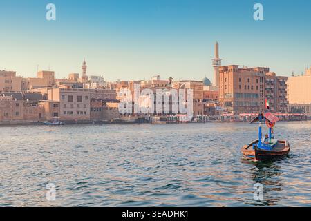 12. Januar 2026, Dubai, Vereinigte Arabische Emirate: Traditionelle Abra-Boote warten auf Passagiere auf Creek, mit der historischen Skyline von Bur Dubai und dem Moscheeminarett im bac Stockfoto
