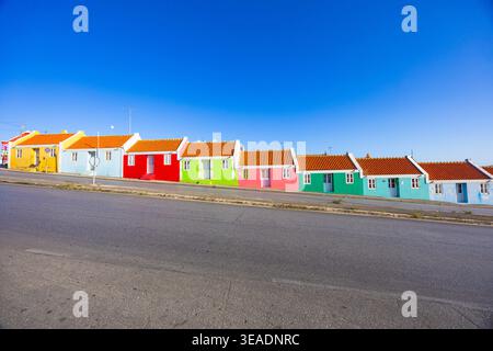 Berühmte Regenbogenhäuser im Bezirk Berg Altena in Willemstad, Curacao, mit lebendiger Kolonialarchitektur unter klarem blauen Himmel Stockfoto