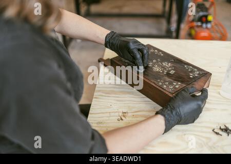 Restaurierung der verzierten Holzkiste mit Handwerkzeugen auf der Werkbank Stockfoto