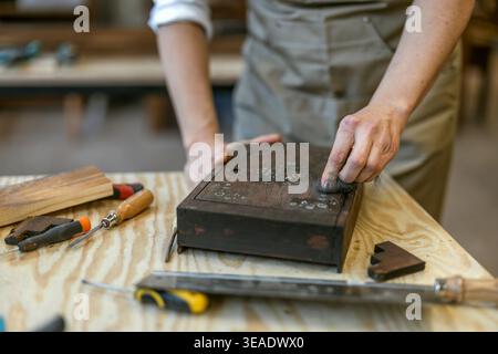 Restaurierung der verzierten Holzkiste mit Handwerkzeugen auf der Werkbank Stockfoto