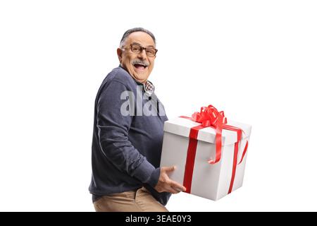 Aufgeregter reifer Mann, der eine Geschenkbox isoliert auf weißem Hintergrund hält Stockfoto