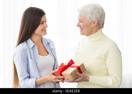 Ältere Mutter erhält Geschenk von erwachsener Tochter Stockfoto
