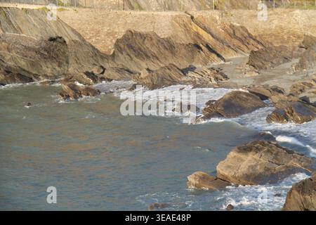 Felsen am Rande eines Küstenmeerestrandes. Stockfoto