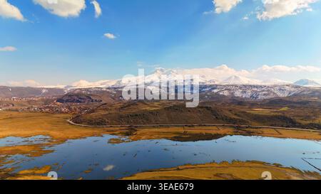Filmische Landschaft eines schneebedeckten Vulkans und Feuchtgebiets Stockfoto