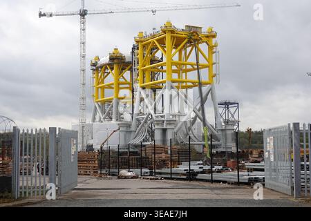 Der Standort zeigt industrielle Aktivitäten am Nordufer des Flusses Tyne in Wallsend, Newcastle. Große Turbinenmäntel sind am Standort Effiage Smulders zu sehen. Baumaschinen und Baumaterialien sind vorhanden, was auf laufende Arbeiten hinweist. Der bewölkte Himmel bildet die Kulisse für die Szene, die aus Sicherheitsgründen von einem umzäunten Bereich umgeben ist. Stockfoto