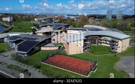 Sunderland University St Peters Campus, am Ufer des Flusses Wear in Sunderland. Die Gebäude verfügen über ein modernes Design und verschiedene Grünflächen. Es sind Sportplätze sichtbar, die einen aktiven Bereich für Schüler anzeigen. Im Hintergrund sehen Sie weitere Gebäude der Stadt, die eine lebhafte Atmosphäre schaffen. Stockfoto