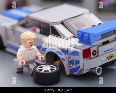 Tambov, Russische Föderation – 21. August 2025 Lego Brian OConner Minifigur wechselt das Rad seines Lego Speed Champions Nissan Skyline GT-R (R34). Stockfoto