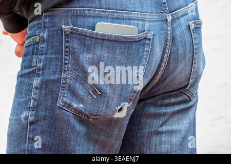 Die Kleidungsdetails mit dem Telefon zeigen den täglichen Gebrauch und das Risiko des Geräteverlusts. Stockfoto