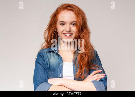 Junge Frau lächelt und posiert in einem Collage-Set mit neutralem Hintergrund und lässiger Kleidung Stockfoto