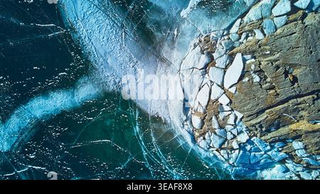 Eismuster und Rocky Shoreline im Winter Top Down Stockfoto