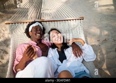 Sorgloses Paar genießt einen tropischen Strandurlaub und lacht zusammen unvergessliche Erinnerungen Stockfoto