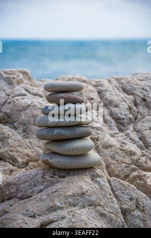 Gestapelte glatte Steine an der Küste von Rocky Beach Stockfoto
