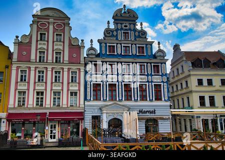 Farbenfrohe historische Fassaden und prunkvolle Barockarchitektur gegenüber einem europäischen Stadtplatz mit Cafés im Freien - Stadt Szczecin. Stockfoto