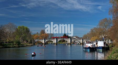 Richmond upon Thames, London. Sehr breites Bild: Menschen, die gemütlich Rudern im Vordergrund, Richmond Bridge in der Ferne. Blauer Himmel, warmer sonniger Tag, März Stockfoto