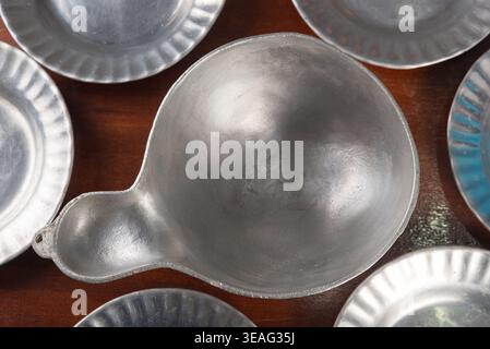 Die Deckenaufnahme verfügt über eine Pfanne aus gebürstetem Aluminium und runde Platten, die auf dunkler Holzoberfläche angeordnet sind. Die sanfte Beleuchtung betont die Metallstruktur und sorgt so für einfache, einfache und einfache Gestaltung Stockfoto