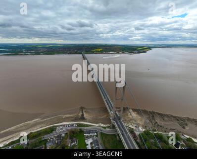 Aus der Vogelperspektive der Humber Bridge Hängebrücke, die die breite Mündung mit grünen Feldern und bewölktem Himmel in Kingston upon Hull, England, United überspannt Stockfoto
