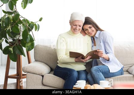 Reife Mutter und Tochter auf der Suche Familie Album Stockfoto