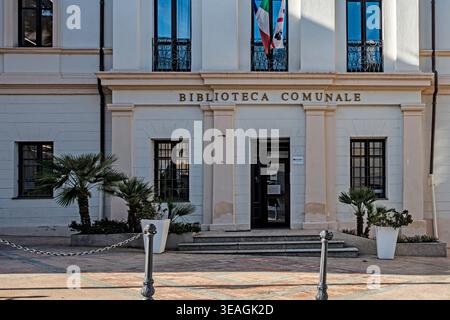 Der Eingang zur Biblioteca Comunale in Olbia, Sardinien, mit weißer neoklassizistischer Architektur, eisernen Fenstern und kleinen Palmen. Stockfoto