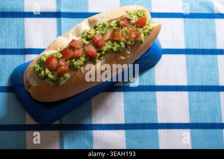 Chilenisches Completo Italiano Sandwich auf einer blauen Platte, klassisches südamerikanisches Street Food Stockfoto