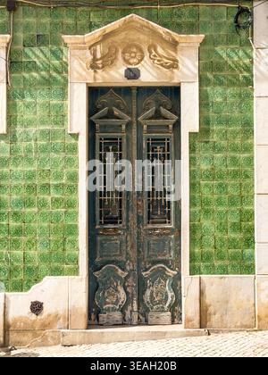 Traditionelles portugiesisches Gebäude Fassade grüne Azulejos Fliesen verwitterte Holztür & Steingiebelgewächshaus Luis de Camoes Square lagos portugal Stockfoto