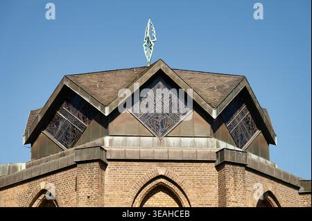 Das achteckige Dach von St. Mauritius in Köln. Moderne Architektur von Fritz Schaller mit diamantförmigen Buntglasfenstern auf historischem Ziegelwerk Stockfoto