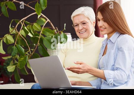 Tochter Lehre ihre betagte Mutter mit Laptop Stockfoto