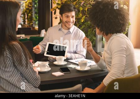 Drei Leute im Restaurant diskutieren Projekt mit digitalen Tablet Stockfoto