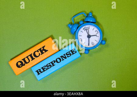 Schnell ansprechende Textblöcke und blauer Wecker auf grünem Hintergrund zur Darstellung der effizienten Zeit Stockfoto