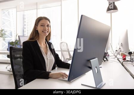 Porträt einer Geschäftsfrau, die im modernen Coworking Office am Schreibtisch sitzt Stockfoto