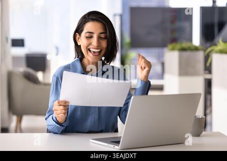 Geschäftsfrau liest Notizen oder Dokumente, feiert Erfolge und Erfolge Stockfoto