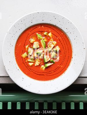 Geschmeidige Tomatenbrühe Mit Avocado-Beilage. Köstliche Vegetarische Mahlzeit In Kunstvoller Keramikschale Stockfoto