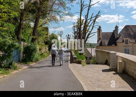 Wunderschöne Straße in Auvers. Im Hintergrund ein Reiseleiter, der als der berühmte niederländische Maler Vincent Van Gogh gekleidet ist Stockfoto