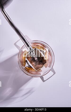 Nebliger Morgentee Mit Reflektionen. Großaufnahme Des Glasgefäßes Mit Gebrühtem Tee Und Sanften Schatten Stockfoto