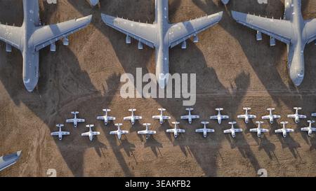 Luftaufnahme von Reihen kolossaler grauer Flugzeuge, die lange Schatten über die kleineren Flugzeuge darunter werfen, Tucson, Arizona, USA. Stockfoto