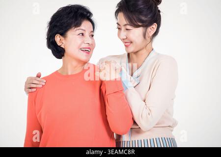 Mutter und Tochter teilen einen warmen Moment, in dem sie sich in einer ruhigen, intimen Umgebung umarmen. Stockfoto