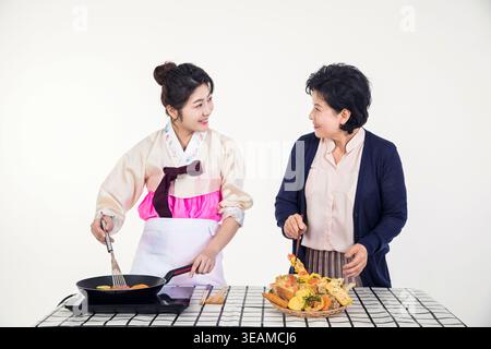 Eine junge Frau und ihre Mutter kochen zusammen in einer Küche. Stockfoto