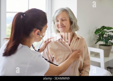 Junger Arztarzt mit Stethoskop zur Untersuchung einer Seniorin in der Klinik Stockfoto