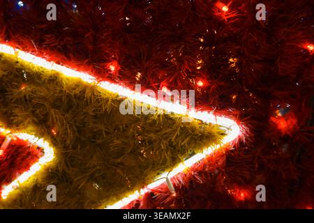 Leuchtende Lichter für Weihnachtsfeiertage Grußkarte Design Dekoration. Weihnachtlicher Hintergrund in roten Farben. Neujahrsthema. Lichter einer roten Girlande auf einem Chri Stockfoto
