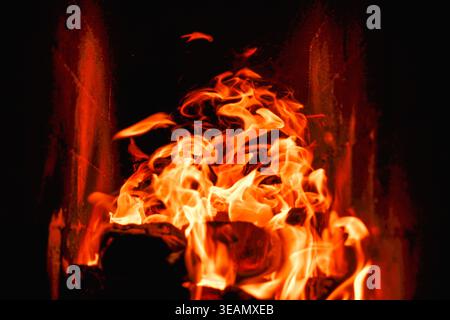 Brennholz und Kohle in einem Steinofen verbrennen. Backofen auf Holz. Lange Zungen von Flammen des brennenden Feuers Stockfoto