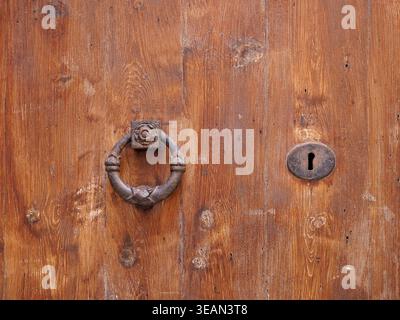 Historischer Metallringklopfer an einer Holztür in Palma Mallorca mit sichtbarer Holzstruktur und Schlüsselloch. Kopierraum Stockfoto