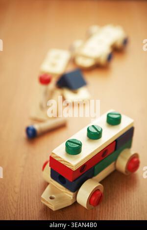 Ein hölzerner Spielzeugwagen aus Blöcken und Schrauben liegt auf einem Tisch. Stockfoto
