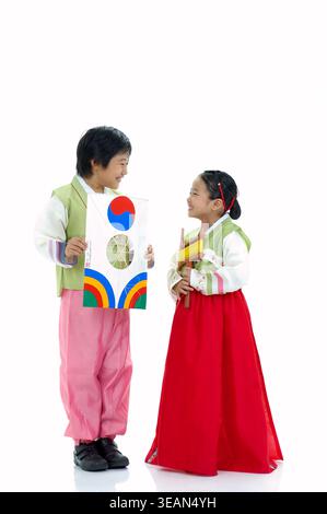 Zwei Kinder in traditioneller koreanischer Kleidung spielen mit einer koreanischen Papierlaterne. Stockfoto