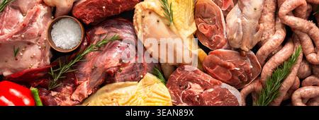 Verschiedene Fleischstücke sind auf dunkler Oberfläche angeordnet. Rindersteaks, Wachteln, Schweinefleischwürste, truthahn, Huhn, und Schweinefleisch sind zusammen mit Kräutern und spi vorhanden Stockfoto