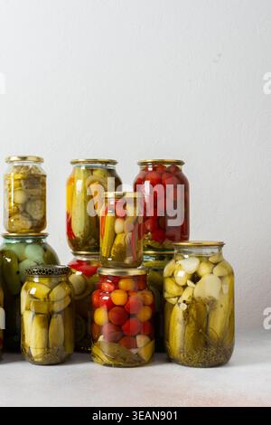 Canning ist eine häufige Aktivität in der Küche, da die Theke mit Gemüse und Obst gefüllte Gläser säumen. Diese Praxis hilft dabei, Lebensmittel für den Gewinn zu bewahren Stockfoto